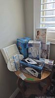 Group shot of boxed GE iron, tower fan, vanity mirror, fabric steamer, dryer balls, iron rest and other items
