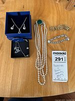 Overview of all jewelry pieces: Swarovski box set, additional Swarovski necklace, faux pearl necklace, two bracelets