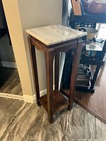 Full view of stand showing stone top and wood frame