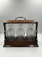 Front view of oak tantalus holding three cut crystal decanters