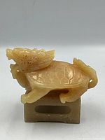 Side view of carved stone dragon on stone base