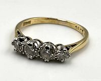 Ring angled view showing yellow gold band and four diamonds in platinum setting