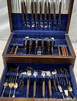 Full view of open cutlery chest showing Dansk teak flatware and extra pieces