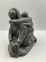 Front three-quarter view of signed soapstone mother and child sculpture