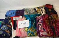 Full lot of 14 folded scarves showing variety of colours and prints
