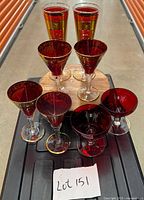 Full group of eight red and gold glasses on table