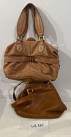 Two brown leather handbags, satchel above hobo style below