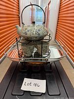 Front view of teapot on caddy with four cups