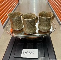 Front view of three speckled stoneware mugs