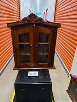 Full front view of wall curio cabinet showing glass doors and overall size