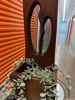 Close view of teak planter box, faux eucalyptus, and mirror detail