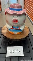 Front view of ceramic pig cookie jar with hat lid