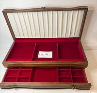 Box open showing white satin lid lining and red velvet tray sections