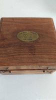 Closed wooden box showing brass oval plate marked SUN DIAL COMPASS LONDON