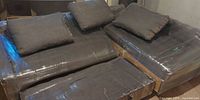 Sofa-bed sections and cushions wrapped in plastic