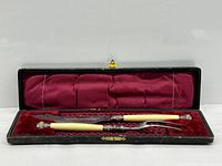 Knife and fork inside red satin velvet lined case