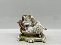Full view of porcelain figurine on chaise