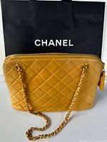 Front view of yellow Chanel quilted leather handbag with chain strap