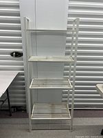 Full view of white four-tier metal shelf unit
