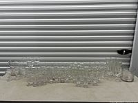 Full group of assorted clear glassware lined on table