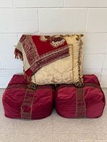 Two poufs stacked with pillow and shawl displayed