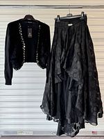 Full view of cardigan on hanger and lace high-low skirt alongside