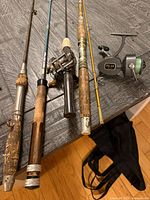 Group of five fishing rods and Polar reel laid on table