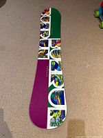 Full top view of snowboard showing graphics and shape