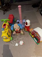 Group view of all items: VTech train, dance puppy, T-Ball set, Fisher-Price barn, IKEA night light