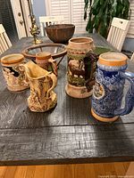 Group view of four steins and pitcher on table