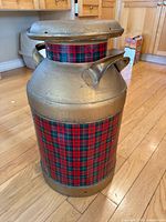 Full view of gold-painted metal milk can with tartan wrap and lid