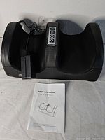 Black electronic foot massager with power adapter and manual displayed