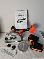 Entire lot showing saw, two batteries, spare blade, wrench, hex key, flanges, manual