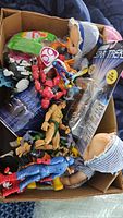 Box filled with loose action figures, two baby dolls, sealed Star Trek figure visible