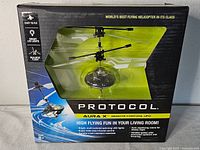 Front of sealed box showing product name, partial view of UFO inside packaging