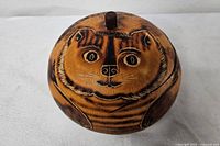 Top view of round gourd trinket box showing cat face design and lid knob