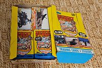 Top view of open Topps Desert Storm retail box showing sealed packs on right, loose cards on left