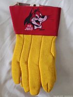 Front view of gloves showing yellow body and red cuff with Mr. Jinks graphic