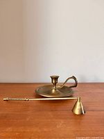 Candle holder and snuffer displayed side by side