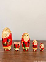 All five wooden Santa nesting doll pieces lined up