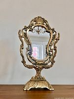 Full view of brass tabletop mirror on pedestal base