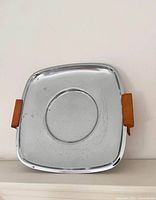 Front view of square chrome tray with handles