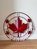 Front view of circular metal Canada compass sign