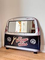 Front view of metal van-shaped mirror sign on floor