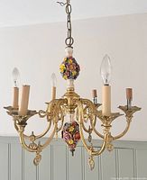 Full view of brass and porcelain chandelier showing six arms and floral porcelain sections