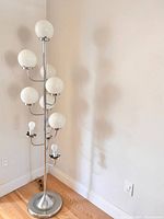 Full view of chrome floor lamp showing all branches, globe shades, and two exposed bulbs