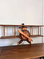 Full view of wooden biplane shelf showing two tiers and overall shape