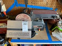 Front view showing Craftsman logo plate, sanding disc, belt, and work table