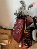 Golf bag with clubs and accessories against wall