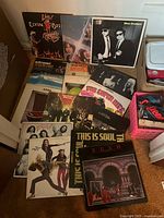 Group shot of all sixteen vinyl records laid out on floor showing cover fronts